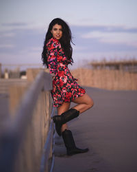 Portrait of beautiful woman at beach against sky