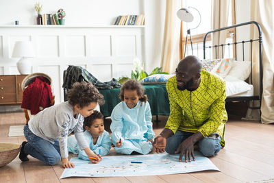 Cute kids with father sitting at home