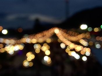 Low angle view of illuminated lights against sky at night