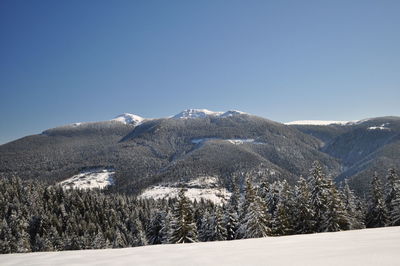 Scenic view of snowcapped mountains against clear sky