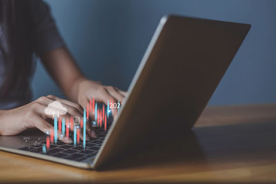 Midsection of man using laptop on table