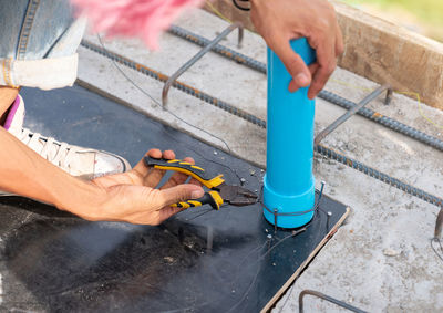 Worker use plies wire bundle tap water in formwork before pour concrete beam.