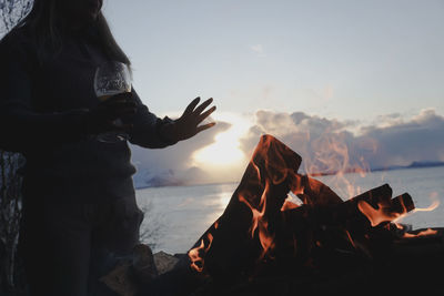 Low angle view of woman on beach during sunset