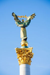 Low angle view of statue against blue sky