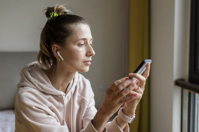 Young woman using mobile phone at home