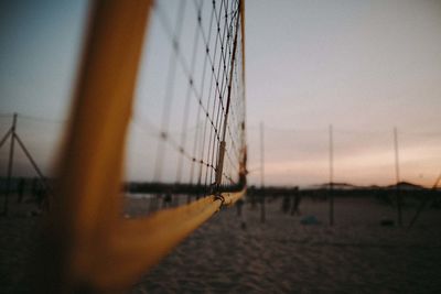 Sailboat on sea shore against sky during sunset