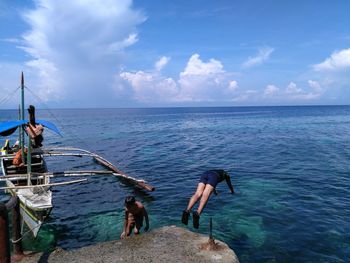 People at beach against sky