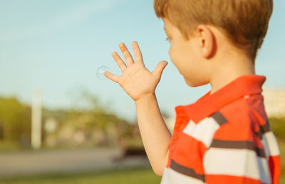 Cute boy playing with bubble at park