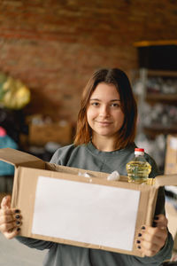 Volunteer teengirl preparing donation boxes for people.