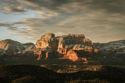 Rock formations on landscape against sky during sunset