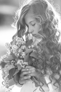 Low angle view of girl holding flowering plant