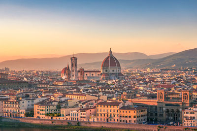 High angle view of buildings in city at sunset