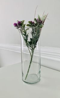 Flower vase on table against glass wall