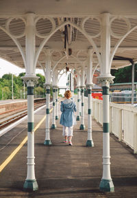 Rear view of woman walking at railroad station platform