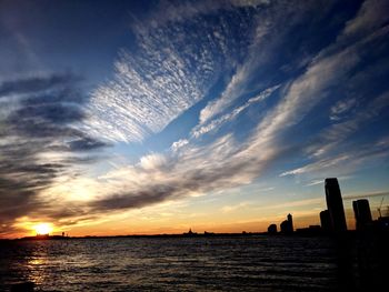 Scenic view of sea against cloudy sky during sunset