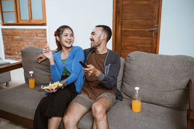 Portrait of happy family sitting on sofa at home