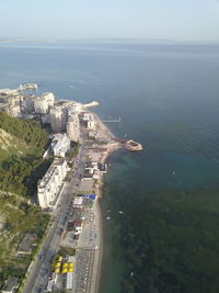 High angle view of sea and cityscape against sky