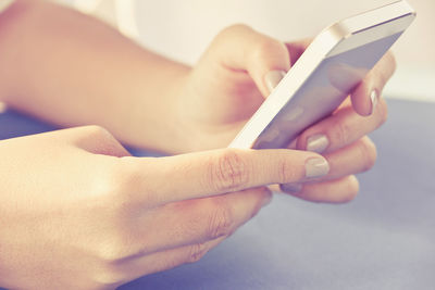 Close-up of hand holding mobile phone in city