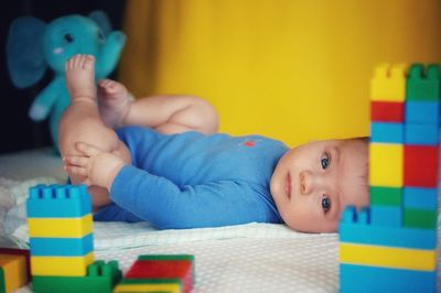 Portrait of baby boy lying on toy