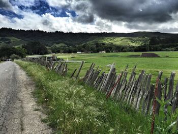 Scenic view of field against cloudy sky