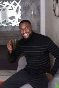 Portrait of a smiling young man drinking glass