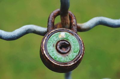 Close-up of raindrops on rusty padlock hanging on metal