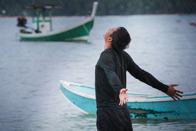 Man enjoying rain at seashore