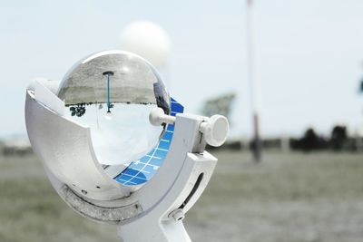 Close-up of crystal ball on equipment against sky