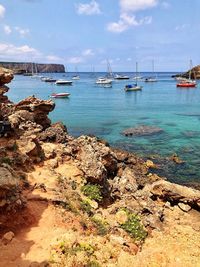 Sailboats moored on sea against sky