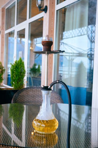 Close-up of glass window on table against building