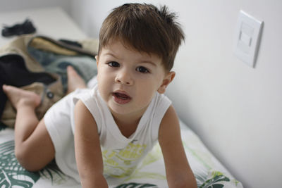 Close-up of boy sitting on bed at home