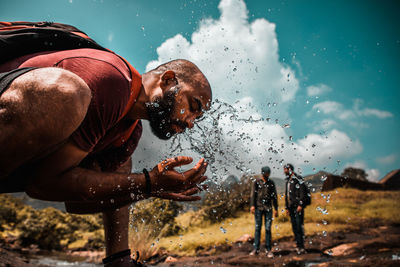 People enjoying in water against sky