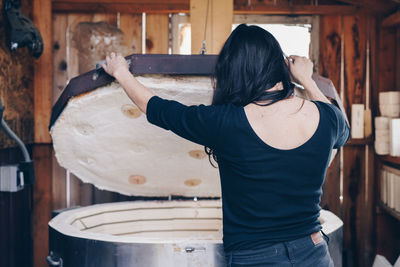 Artist awaits body casting infused glass piece from out of the kiln