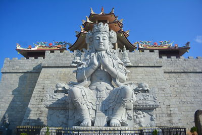 Statues on building against sky