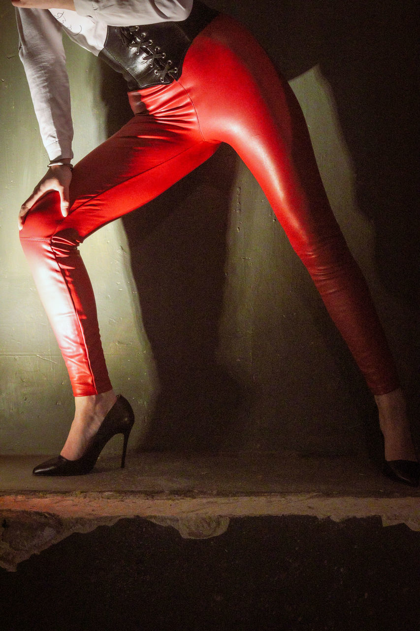 LOW SECTION OF WOMAN IN RED SHOES