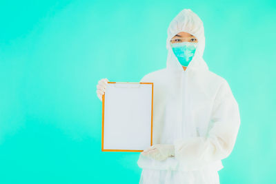 Portrait of man wearing mask against blue background