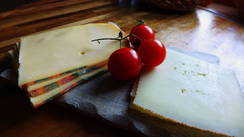 High angle view of cheese and cherry tomatoes on cutting board at home