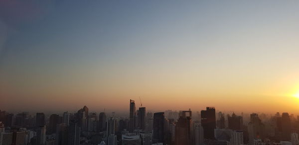 Modern buildings against clear sky at sunset