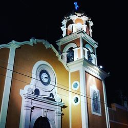 Low angle view of bell tower against sky at night