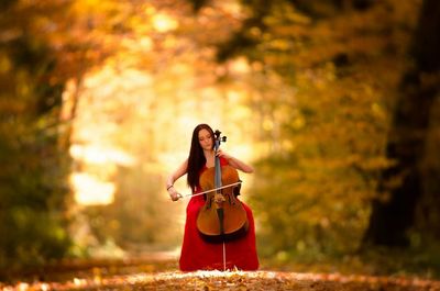 Woman sitting on tree trunk