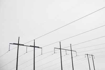 Low angle view of electricity pylon against clear sky