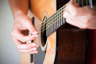 Midsection of man playing guitar