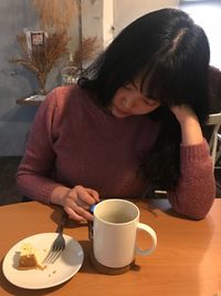 High angle view of woman using phone in cafe