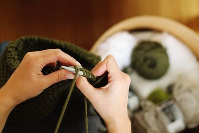 Cropped hands of woman knitting wool