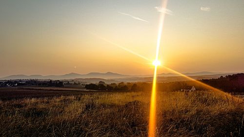 Scenic view of field against sky during sunset