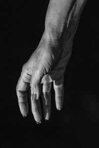 Cropped image of woman hand against black background