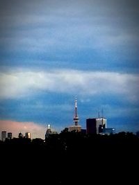 Silhouette of city against cloudy sky