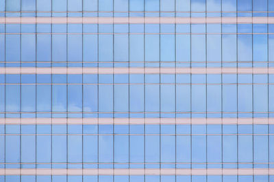 Modern office building elevation. glass curtain wall repeating pattern reflecting cloud.