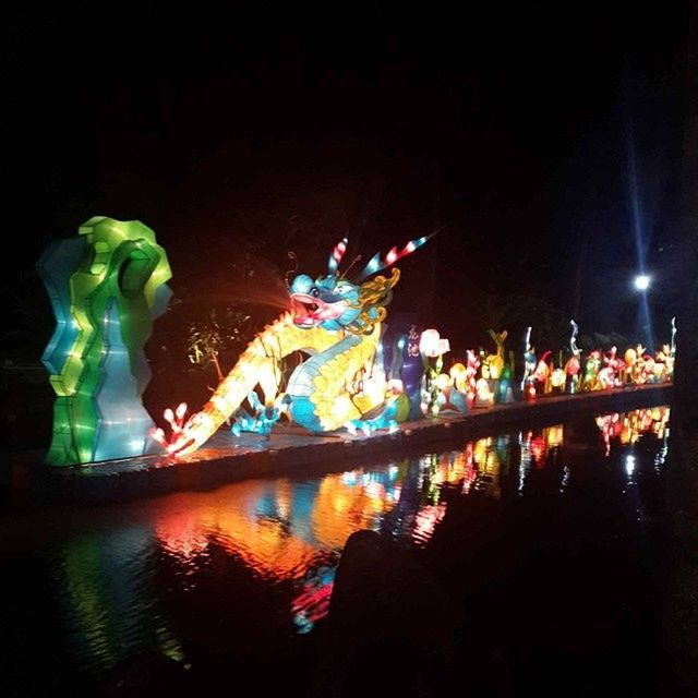 illuminated, night, water, lighting equipment, reflection, multi colored, glowing, long exposure, light - natural phenomenon, motion, decoration, celebration, copy space, dark, waterfront, creativity, art and craft, sea, art, no people