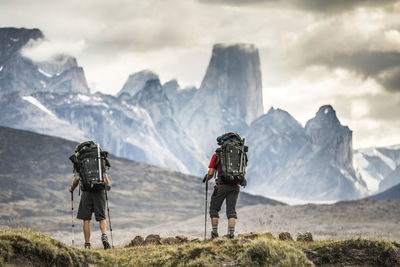 Rear view of people on mountain against sky